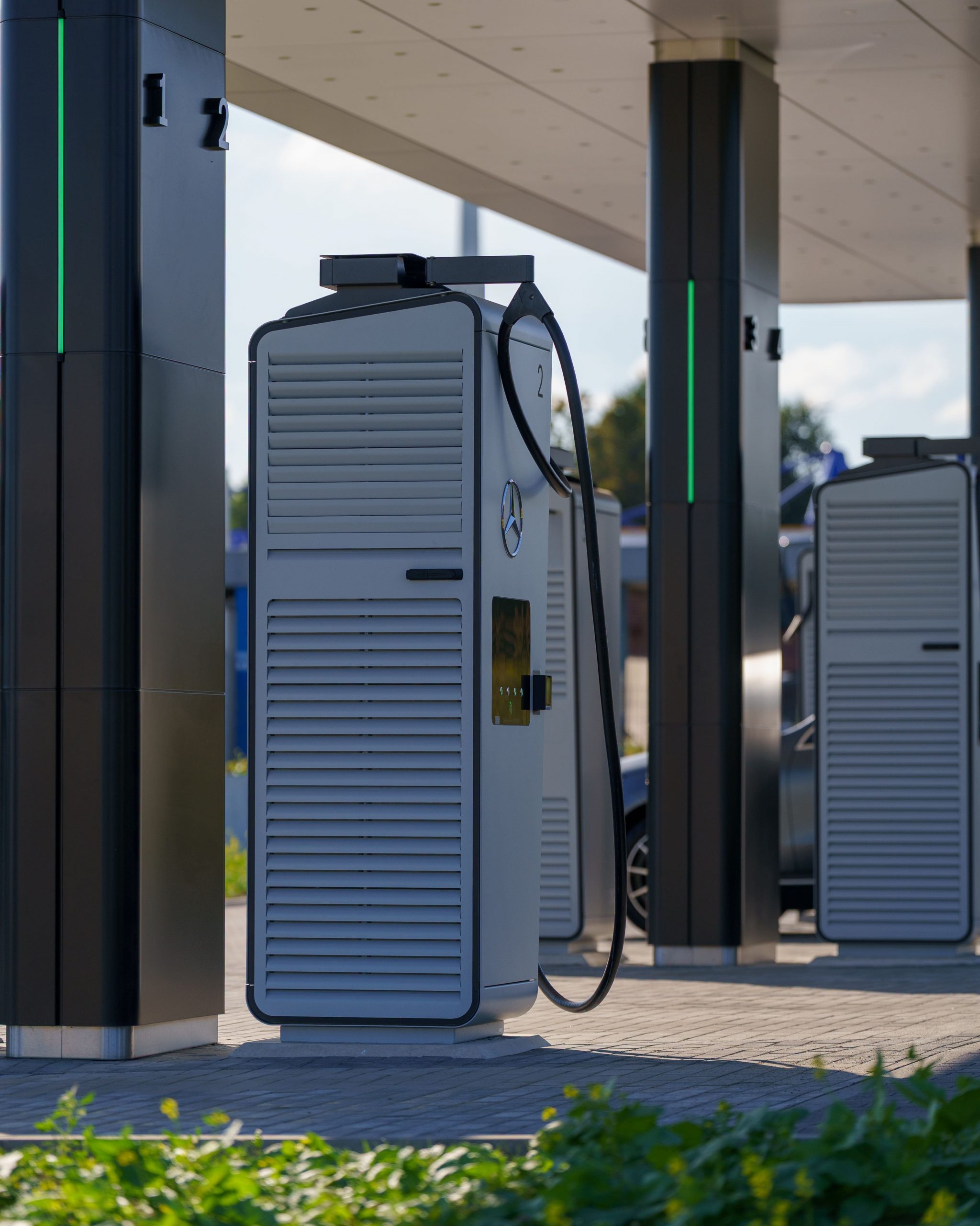 Modern electric vehicle charging stations with multiple EVs charging in a clean, eco-friendly urban environment powered by renewable energy.