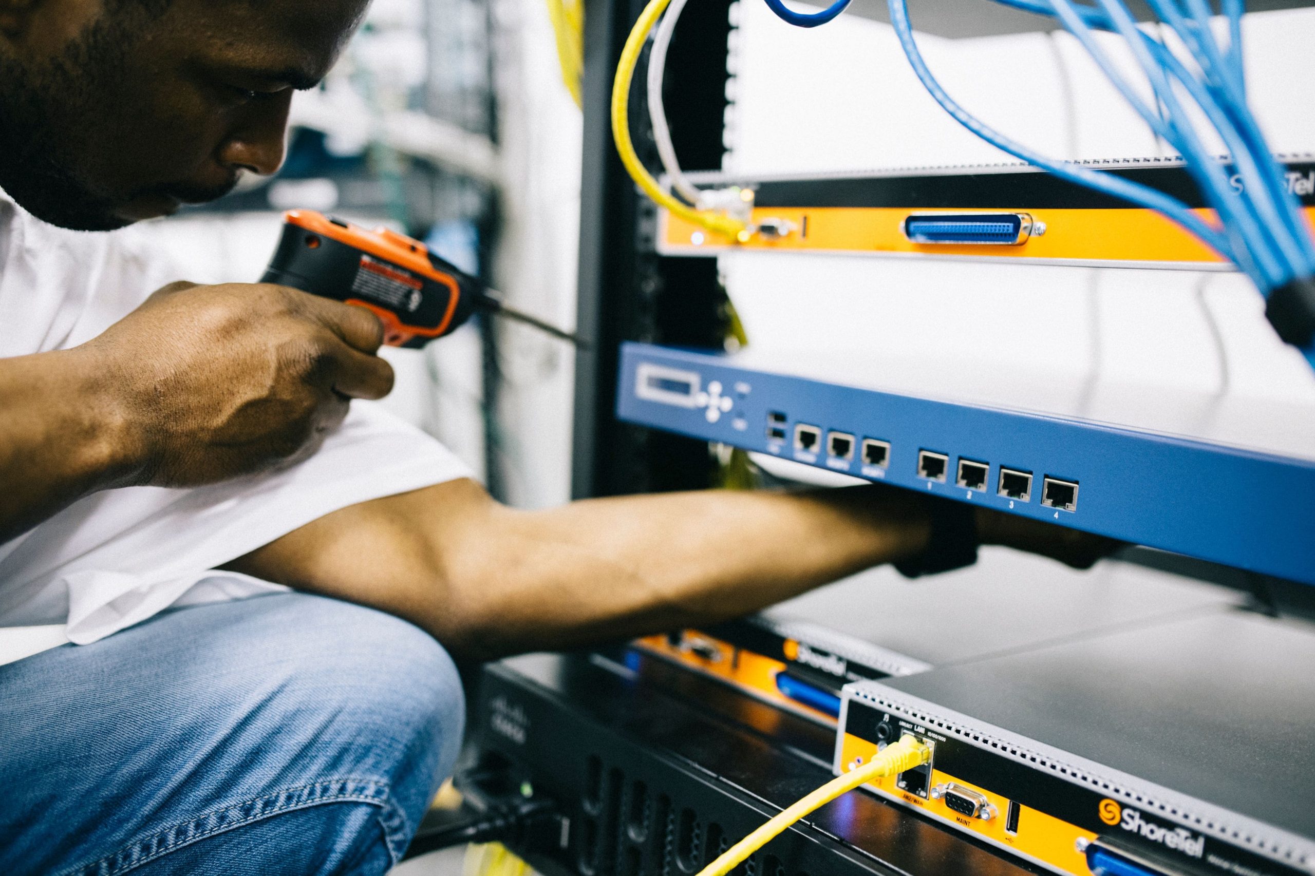 Professional technician installing smart home devices, including a smart thermostat, security camera, smart lighting, and voice-controlled home automation system.